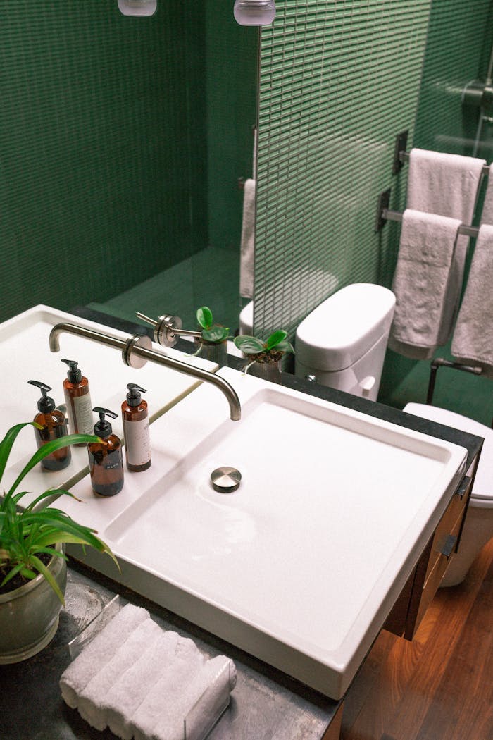 our-experience Elegant green bathroom features modern sink and stylish fixtures.